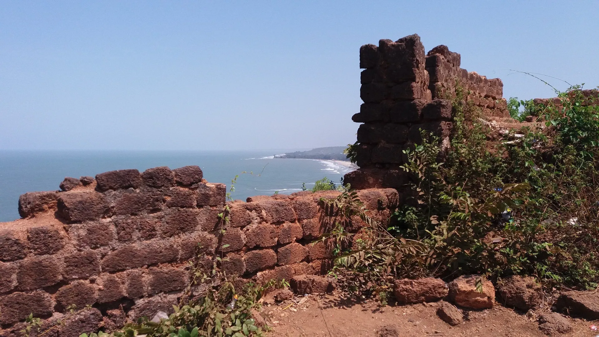 Crumbling laterite walls of Chapora Fort above the Arabian Sea on a clear day, Vagator, North Goa