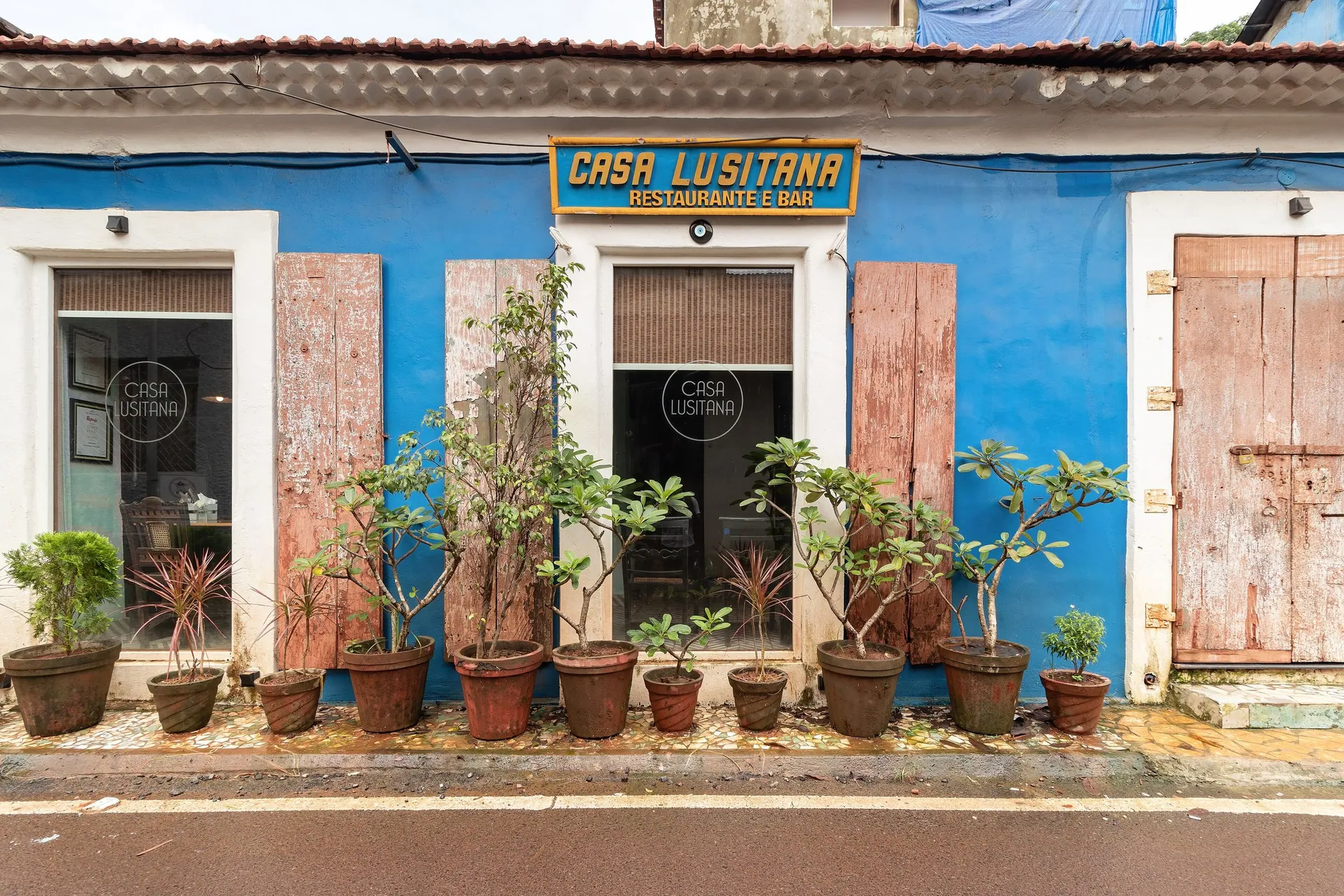 A blue Portuguese-era building with wooden shutters and potted plants in Fontainhas, Panjim