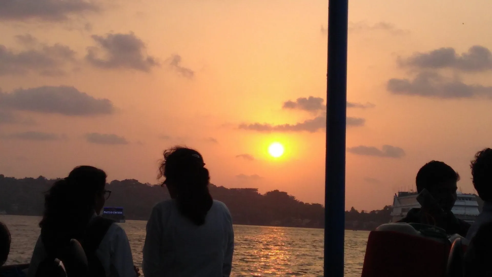 Passengers watching the sunset from a ferry crossing the Mandovi river in Goa