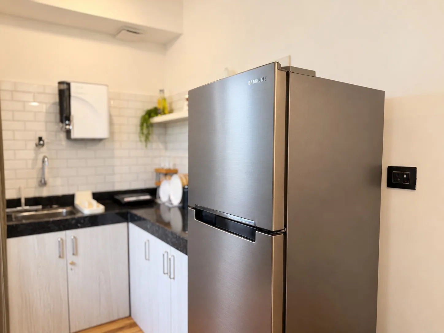 The double-door fridge beside the kitchen counter and sink at Rivara