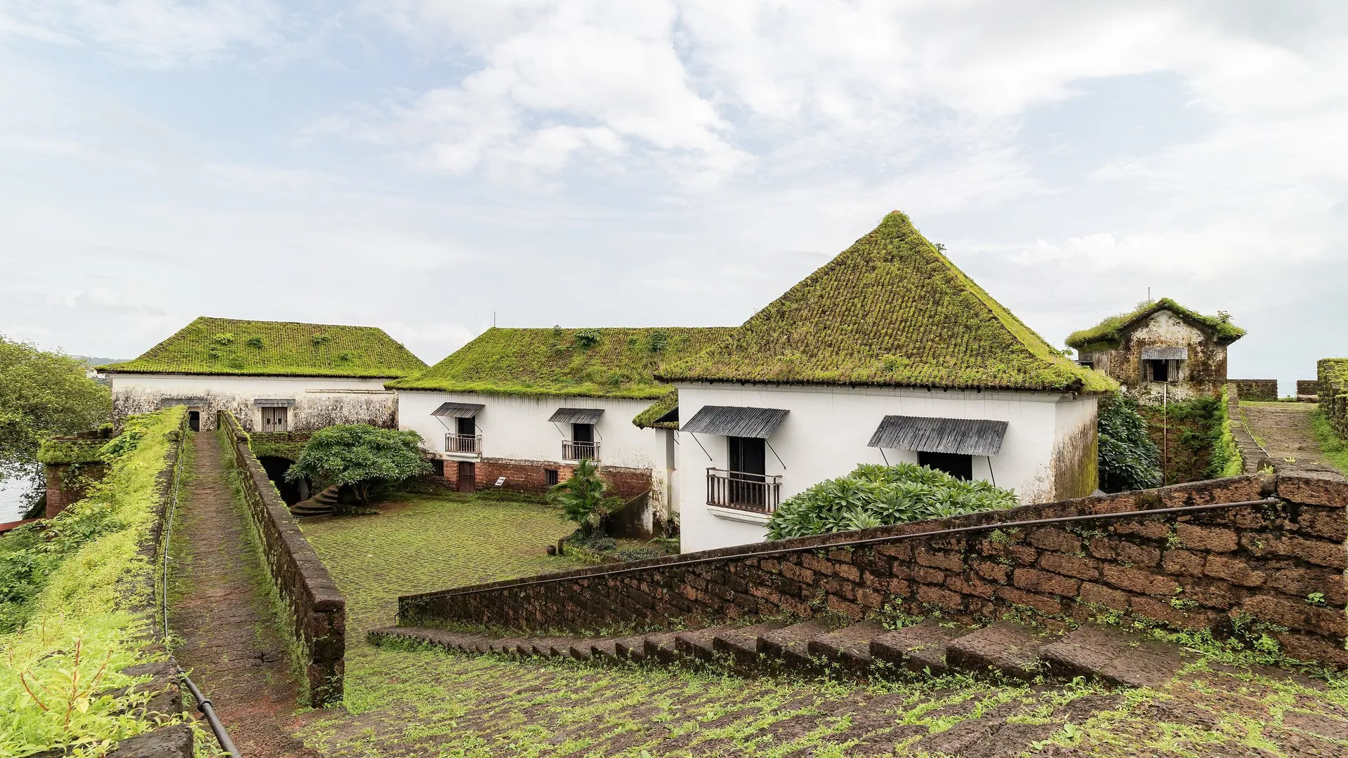 Buildings with moss-green roofs on the citadel of Reis Magos Fort, across the Mandovi from Panjim