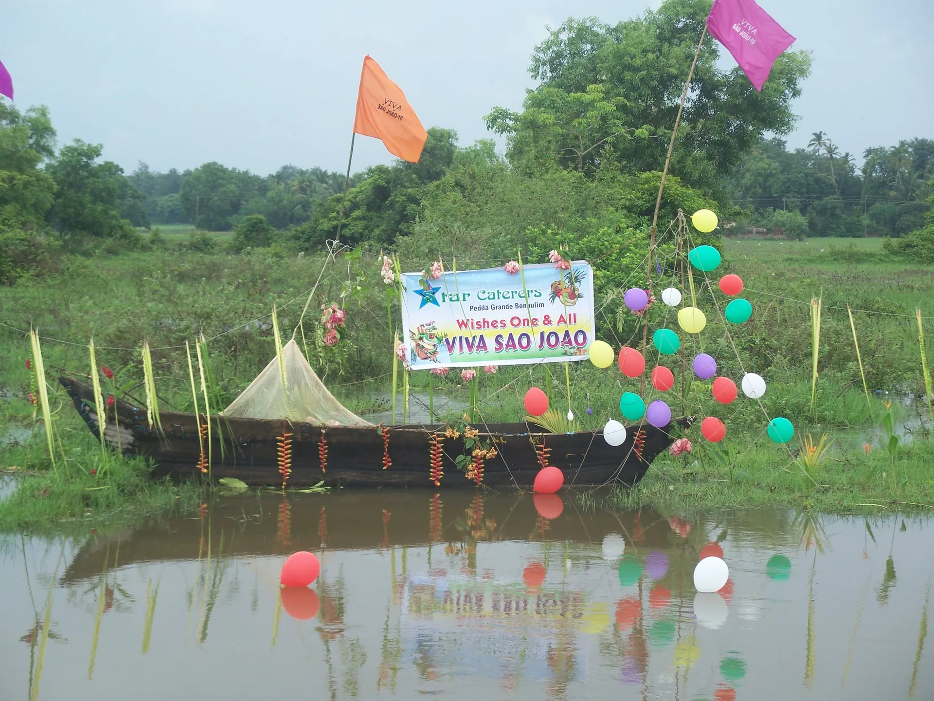 A boat decorated for São João in Benaulim, Goa, on the water in the monsoon