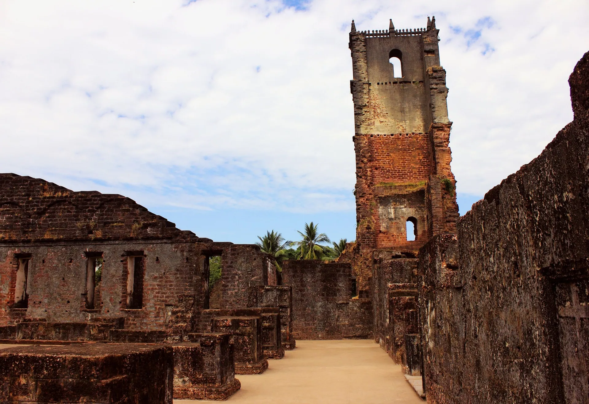 The ruined bell tower of the Church of St. Augustine above laterite walls, Old Goa